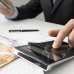 business-man-calculating-finance-numbers-close-up-min